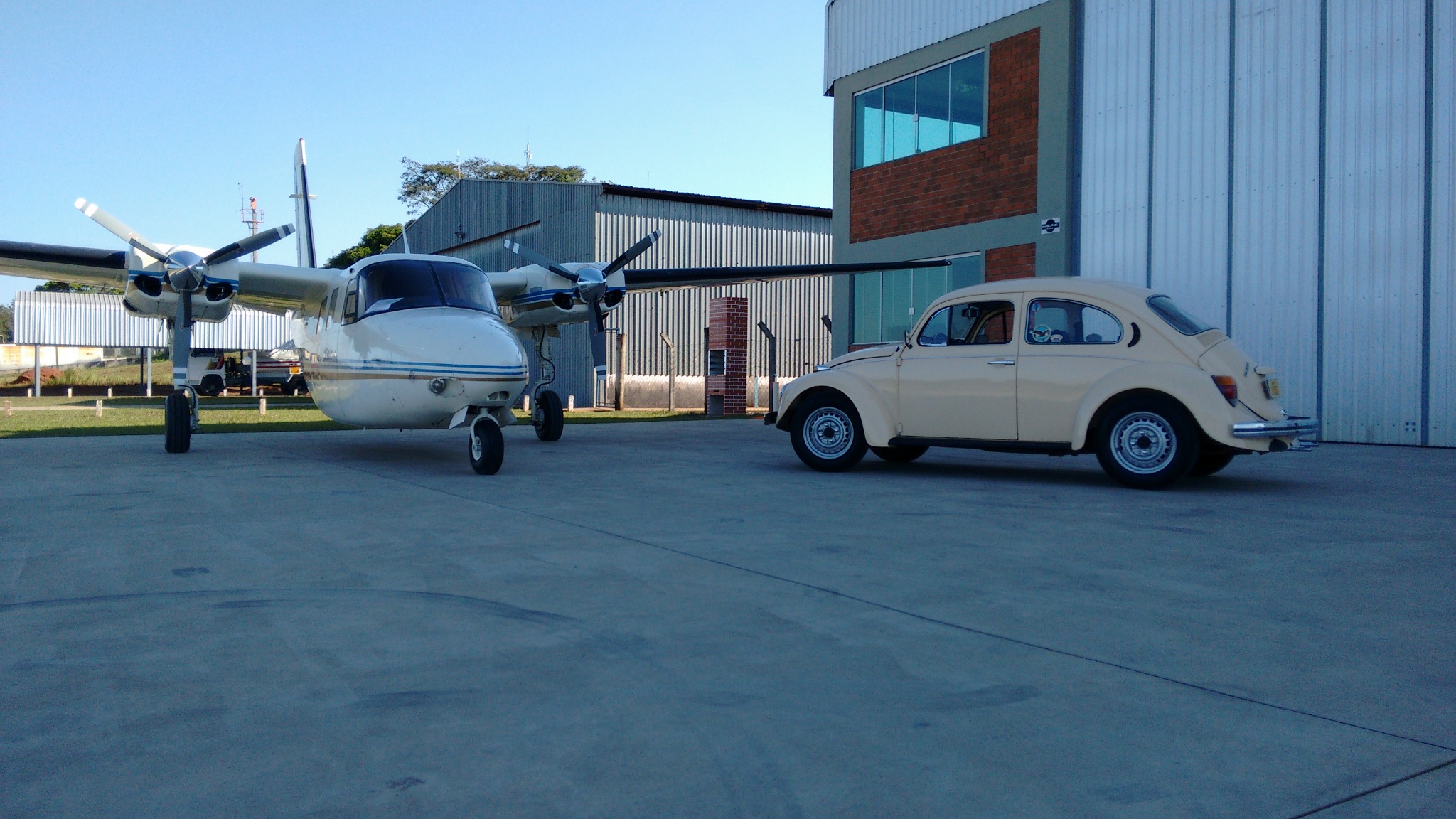 Fusca com avião ao fundo